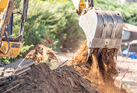 Excavator Removing Dirt and Debris from Property Site