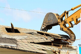 Roof of House Being Demolished by Excavator